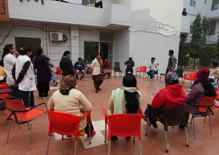 Residents participating in a group activity in the outdoor area at Saksham by Kriti