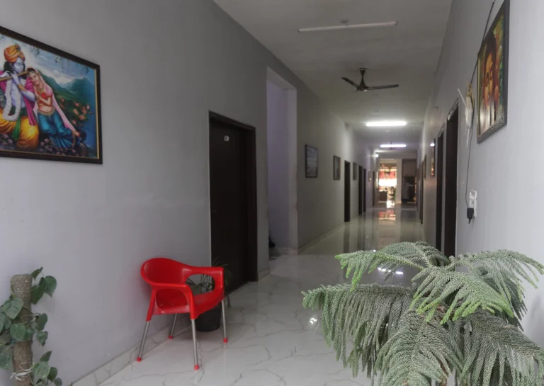 Residential interior corridor with artwork and seating at Saksham by Kriti