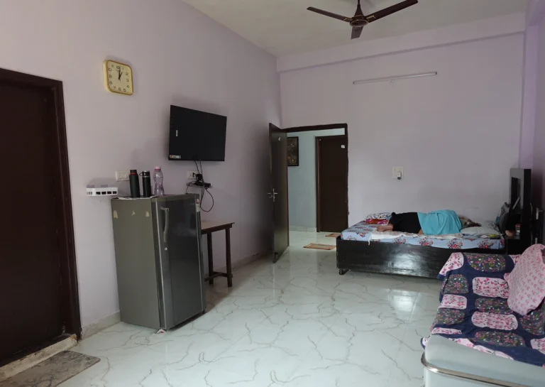 Residential room with bed, television and seating at Saksham by Kriti in Gurgaon